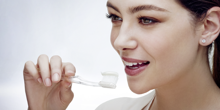 caries prevención mujer cepillar dientes con regenerate dentífrico