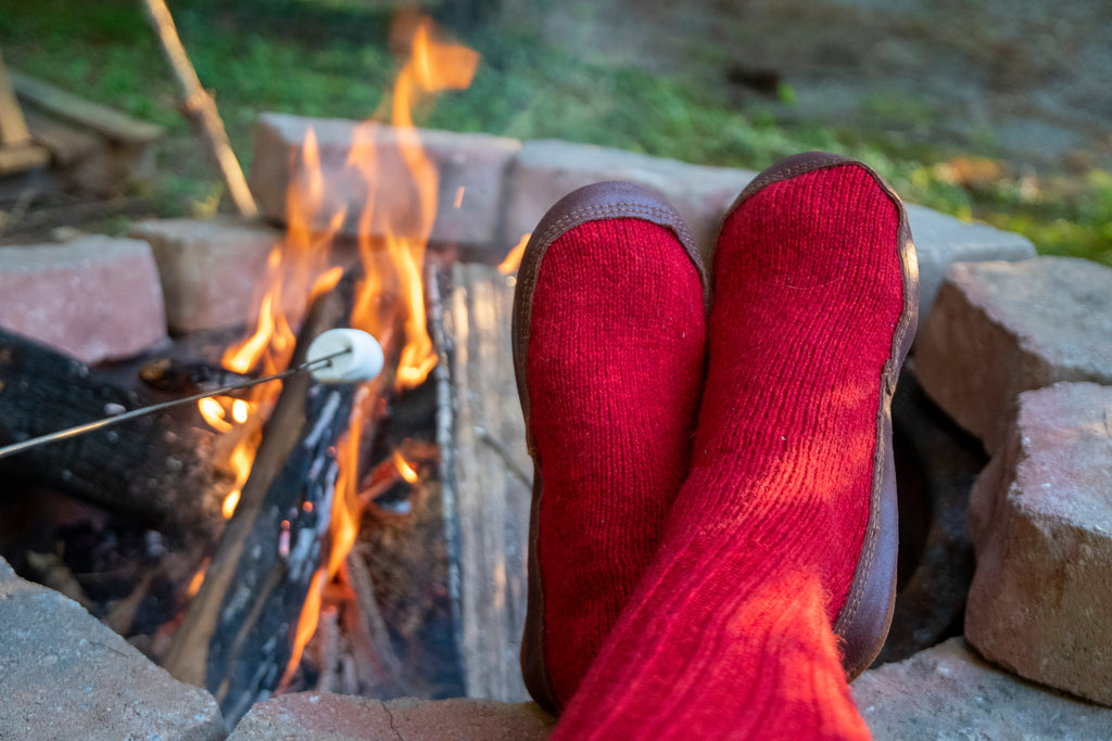 Original Slipper Socks in red around a campfire