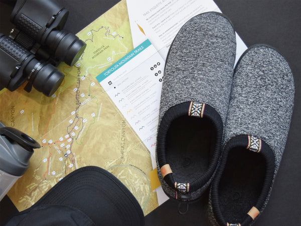 Grey Explorer shoes flatlay with maps, binoculars, hat and water bottle