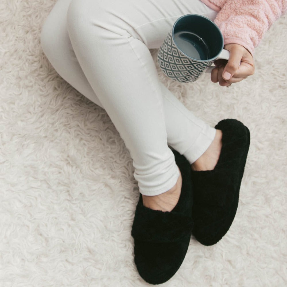 Women's Adjustable Spa Wrap Slippers in Black On Model Sipping Coffee on Fur Rug
