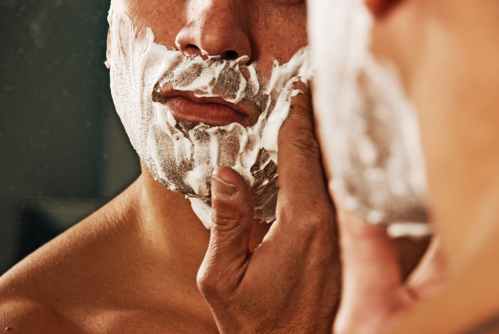 Man shaving in mirror