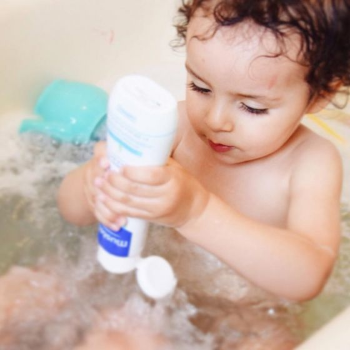 Baby taking a bath with Mustela products