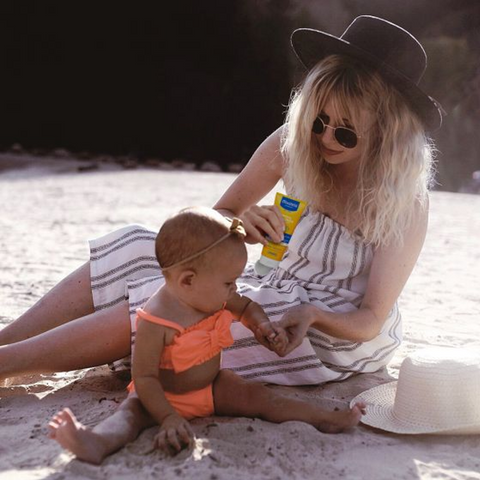 mom playing with baby on beach