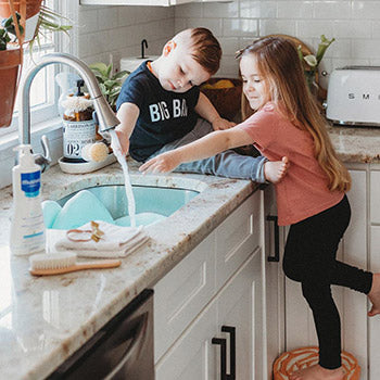 two kids washing hands to prevent the baby flu