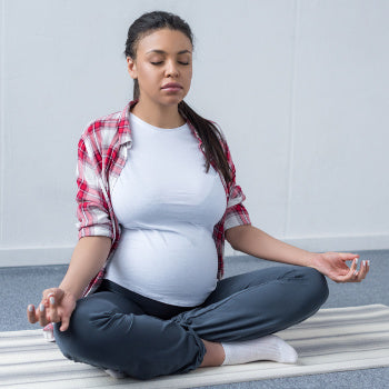Woman meditating to help with her pregnant sleep