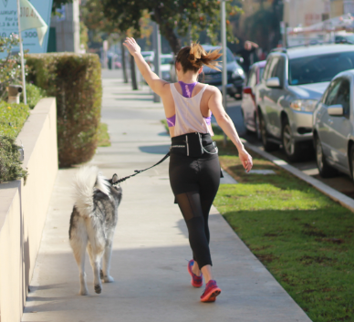 woman walking with dog in quiet neighborhood safe dog walking tips