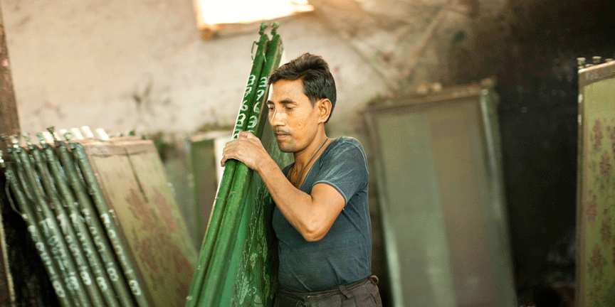 Artisan taking the silkscreens on the factory floor 