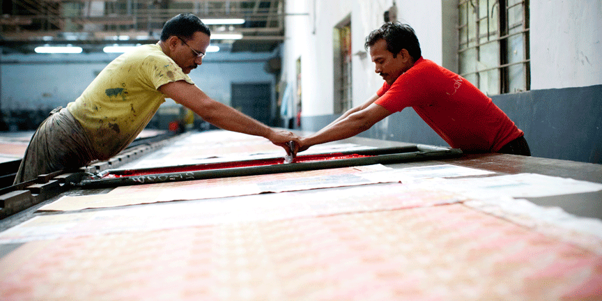 Artisans hand printing the silk textiles with silkscreens 