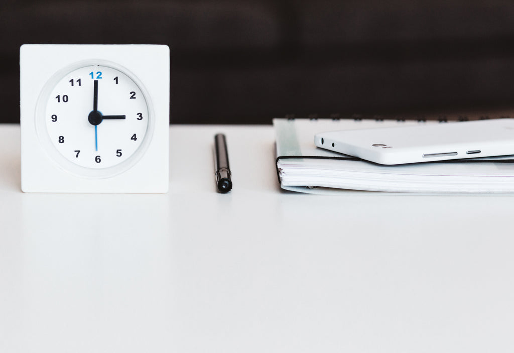 Flexibility is a curse and a blessing: A work desk with a clock, a pen and a notebook