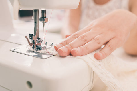 A woman sewing with a sewing machine.