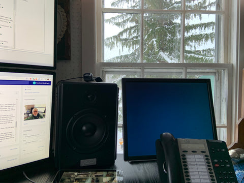 View of snow-covered pine tree and farm land from John's home office