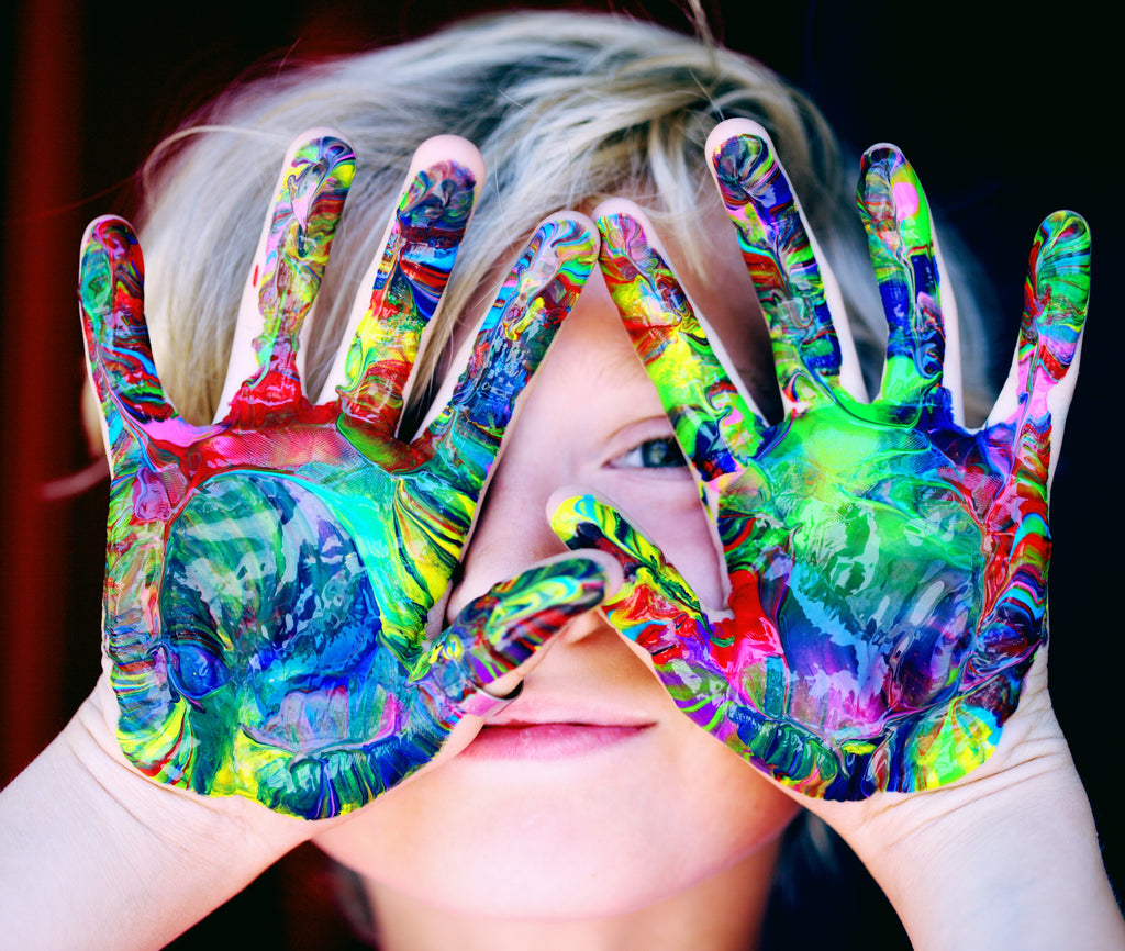 adorable boy with colorful paints in his hands
