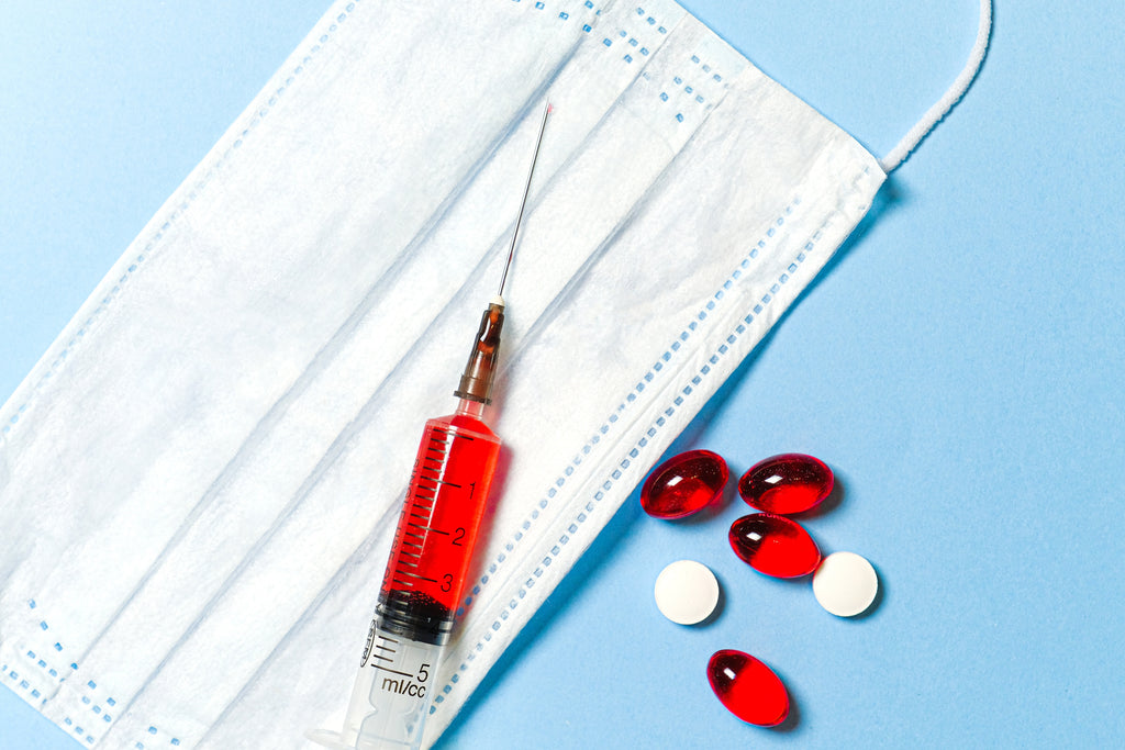 syringe, pills, and mask on a blue background