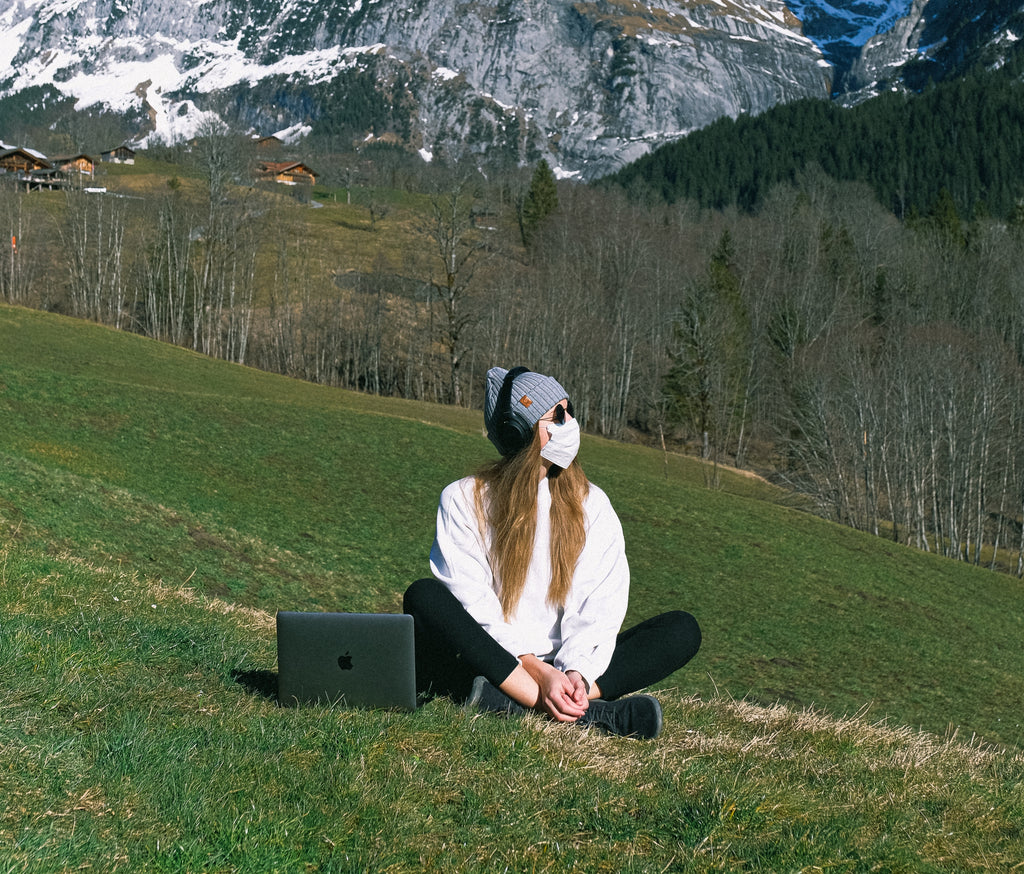 a woman wearing facemask on a mountain