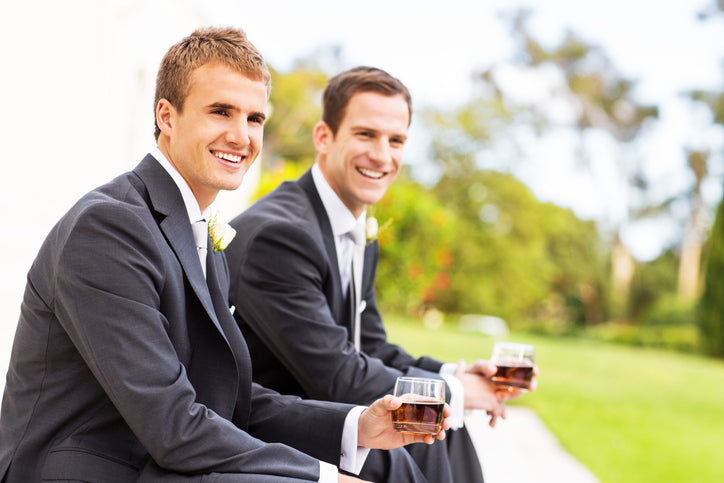 A groom and his best man drinking whiskey before the ceremony