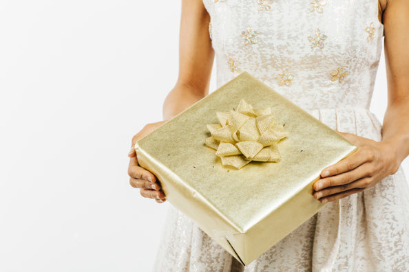 A bride holding a gift for her groom on their wedding day