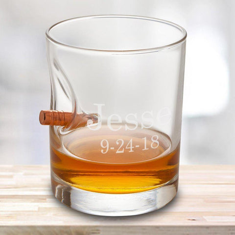 A personalized whiskey glass that says Jesse with a bullet lodged into the side 
