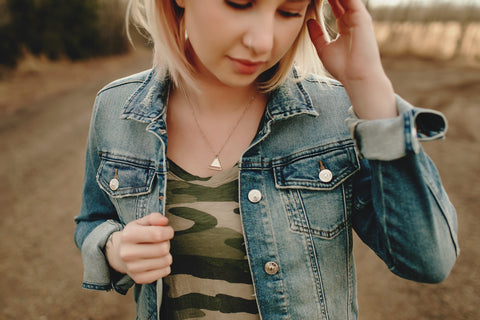 girl looking down with necklace on