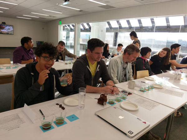 people sitting at a table tasting chocolate paired with whiskey