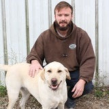 English cream lab with his owner demonstrating responsible ownership