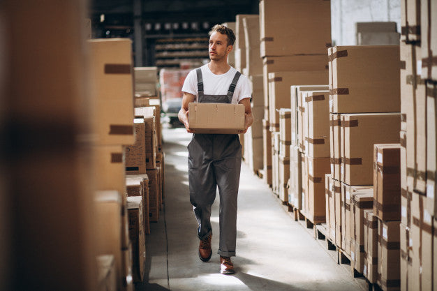 A warehouse worker placing a box of returned Amazon packages