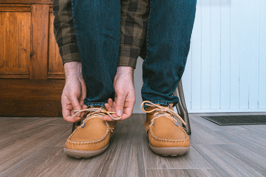 tying laces on a pair of moccasin boots
