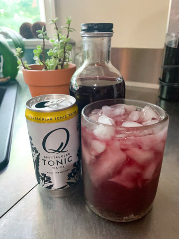 Christina Maser Co. Blueberry Shrub with a can of tonic water and a cocktail glass.