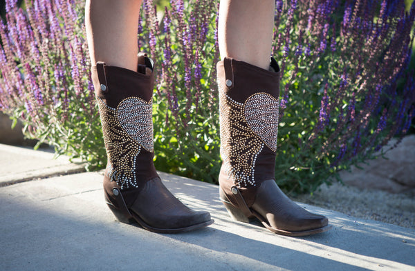 brown cowboy boots with cowgirl boot covers with a rhinestone design of a heart with wings