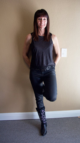 Brunette woman wearing a black shirt and black pants with cowboy boots
