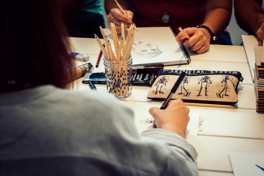 Image over someones shoulder while they are drawing with FRANK pencils