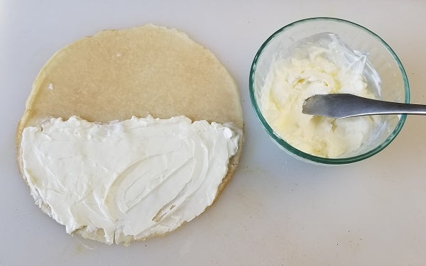Place one crêpe on a cutting board, spread filling over one half of the crêpe, then fold the other half over the filling, then fold it in half again.