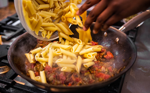 Add in the crushed tomatoes, ¼ cup extra virgin olive oil and the white wine. Bring the mixture to a slow boil.