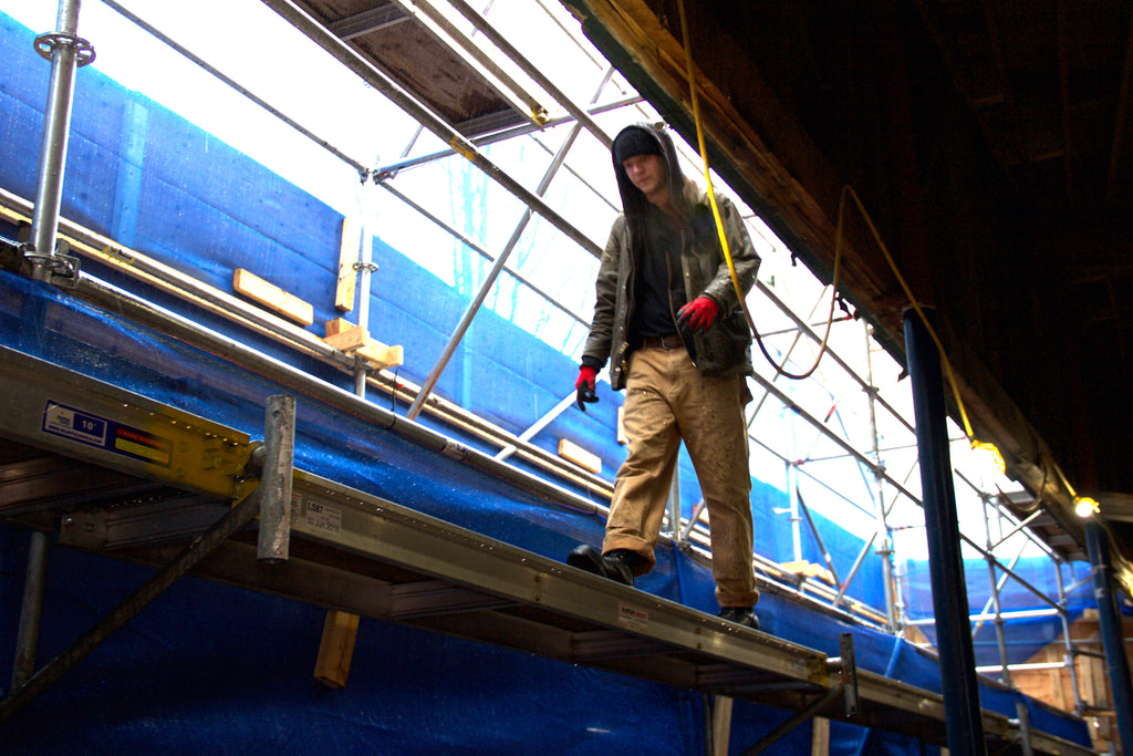 Dan walking on the scaffolding in his Rigger work boots