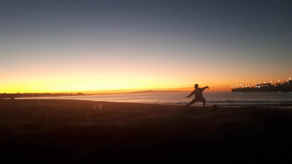 Emily Drysdale practising Qigong on Santa Cruz beach at sunrise