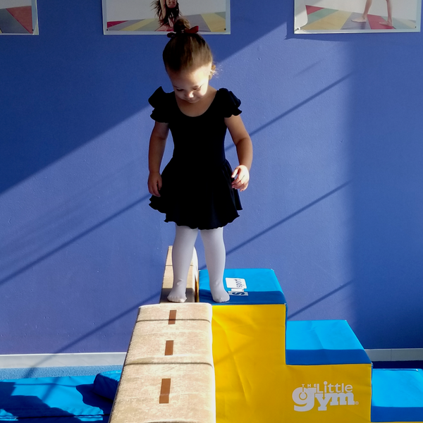 Toddler at gymnastics wearing a leotard