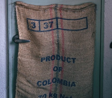 Kolombiya kahve çuvalı kapıya yaslanmış şekilde duruyor.