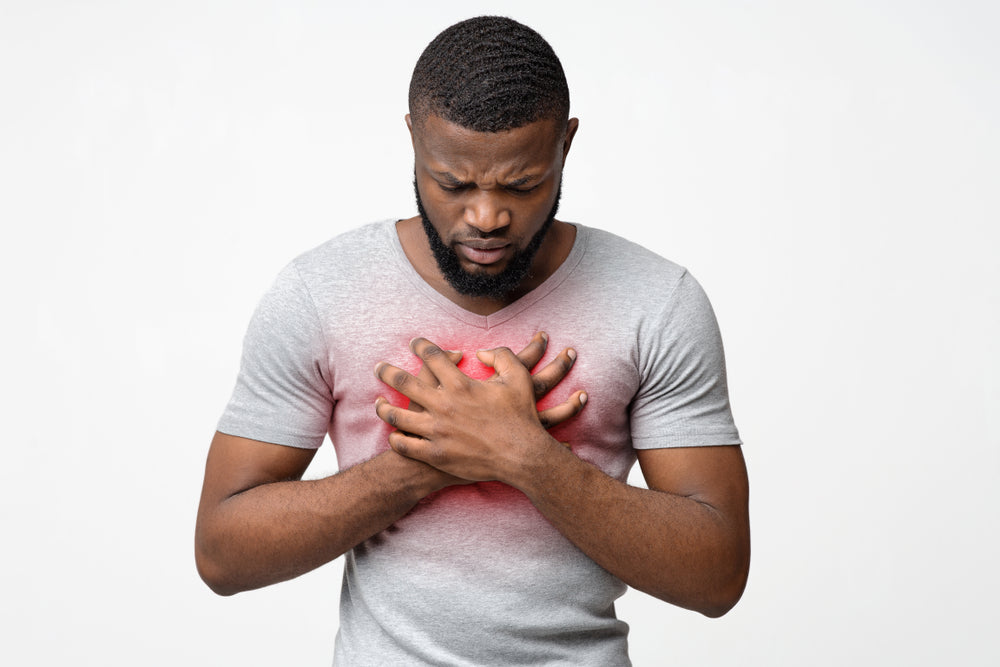 Man suffering from acid reflux during the day - holding chest