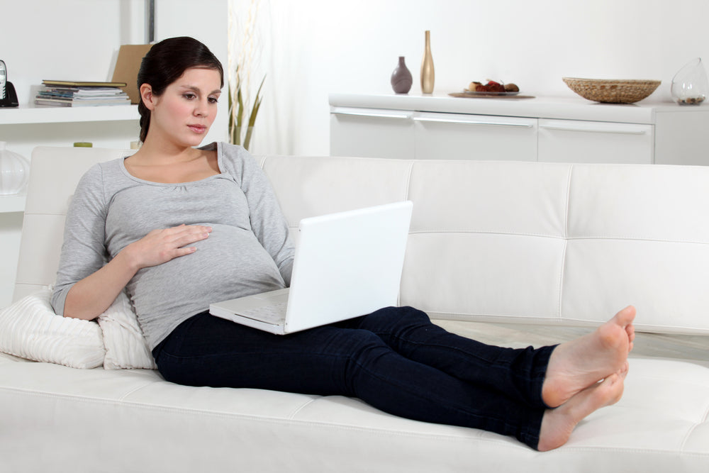 Pregnant woman researching pregnancy pillows online