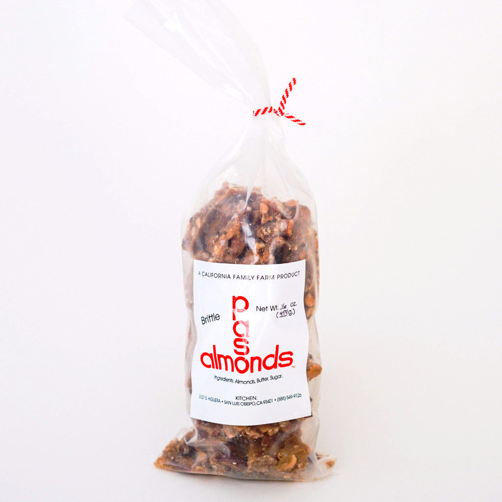 plastic bag filled with almond brittle, closed by a red twist tie, and a label on the front