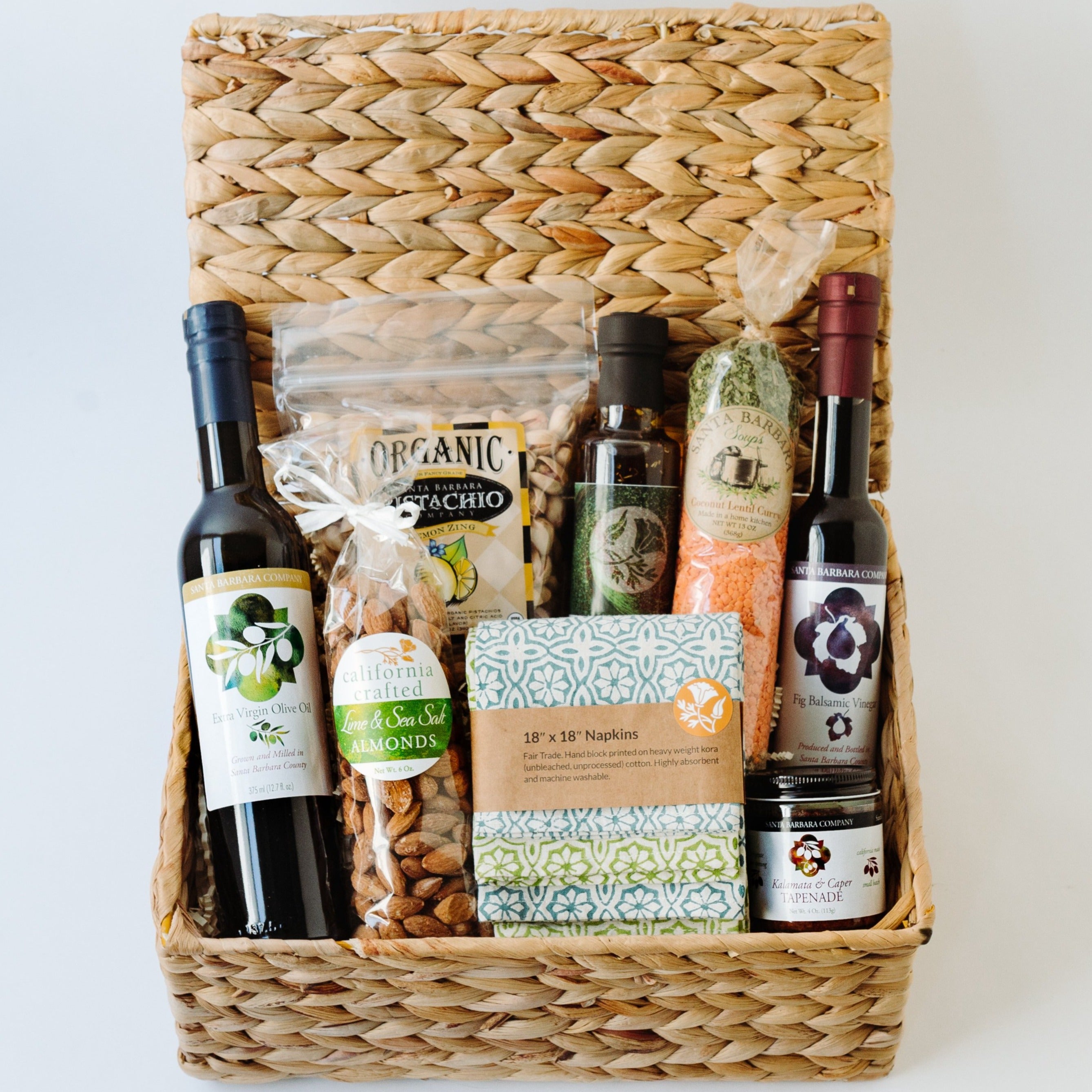 Basket with oil, vinegar, pistachios, almonds, soup, and napkins