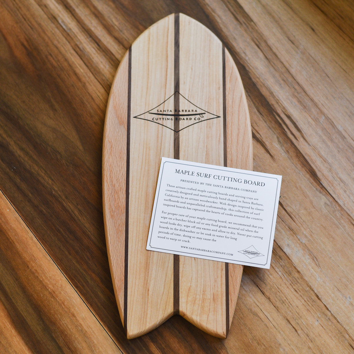 small surf board shaped cutting board on a table