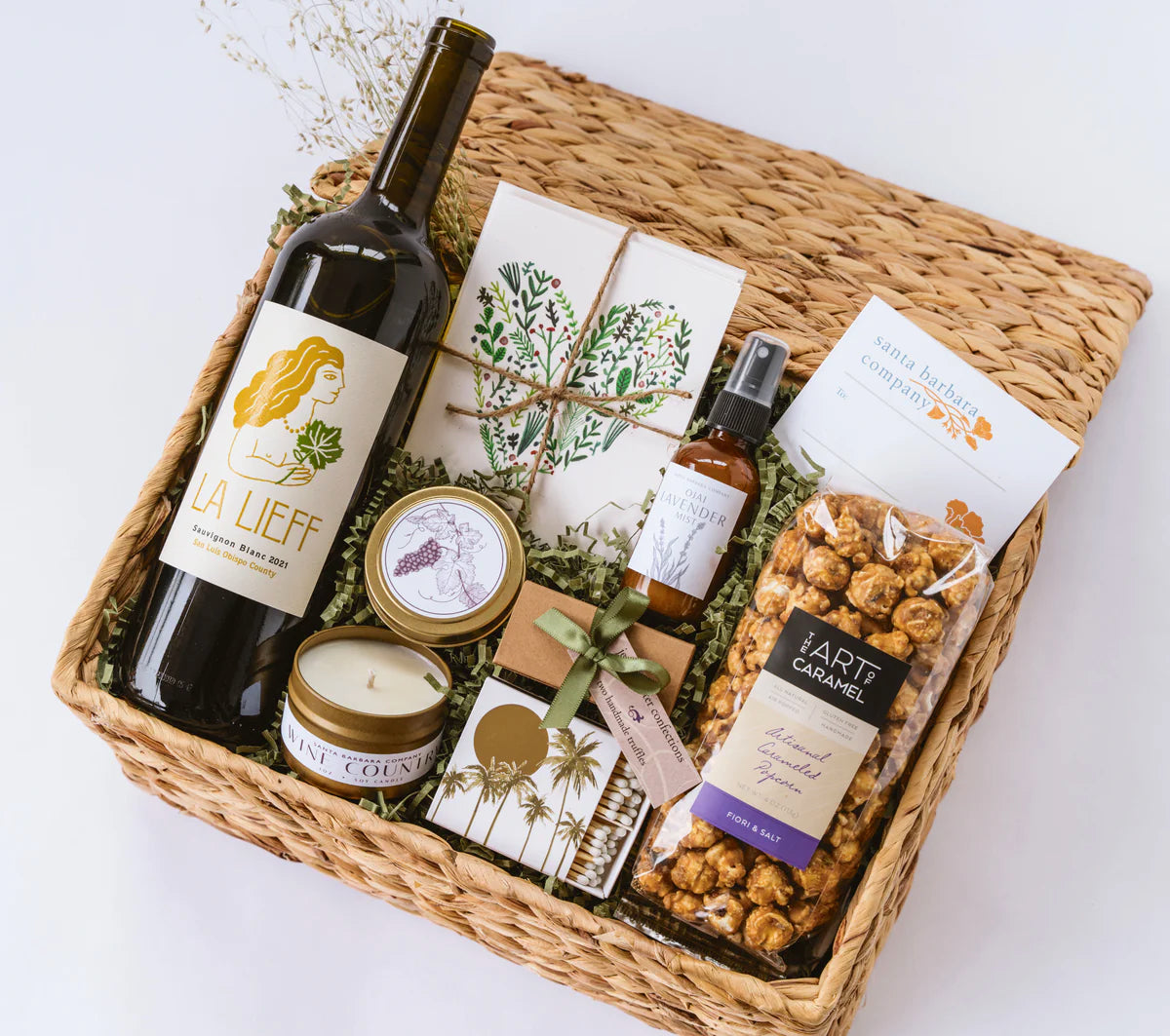 Basket with wine, cards, popcorn, a candle, matches, body spray and truffles