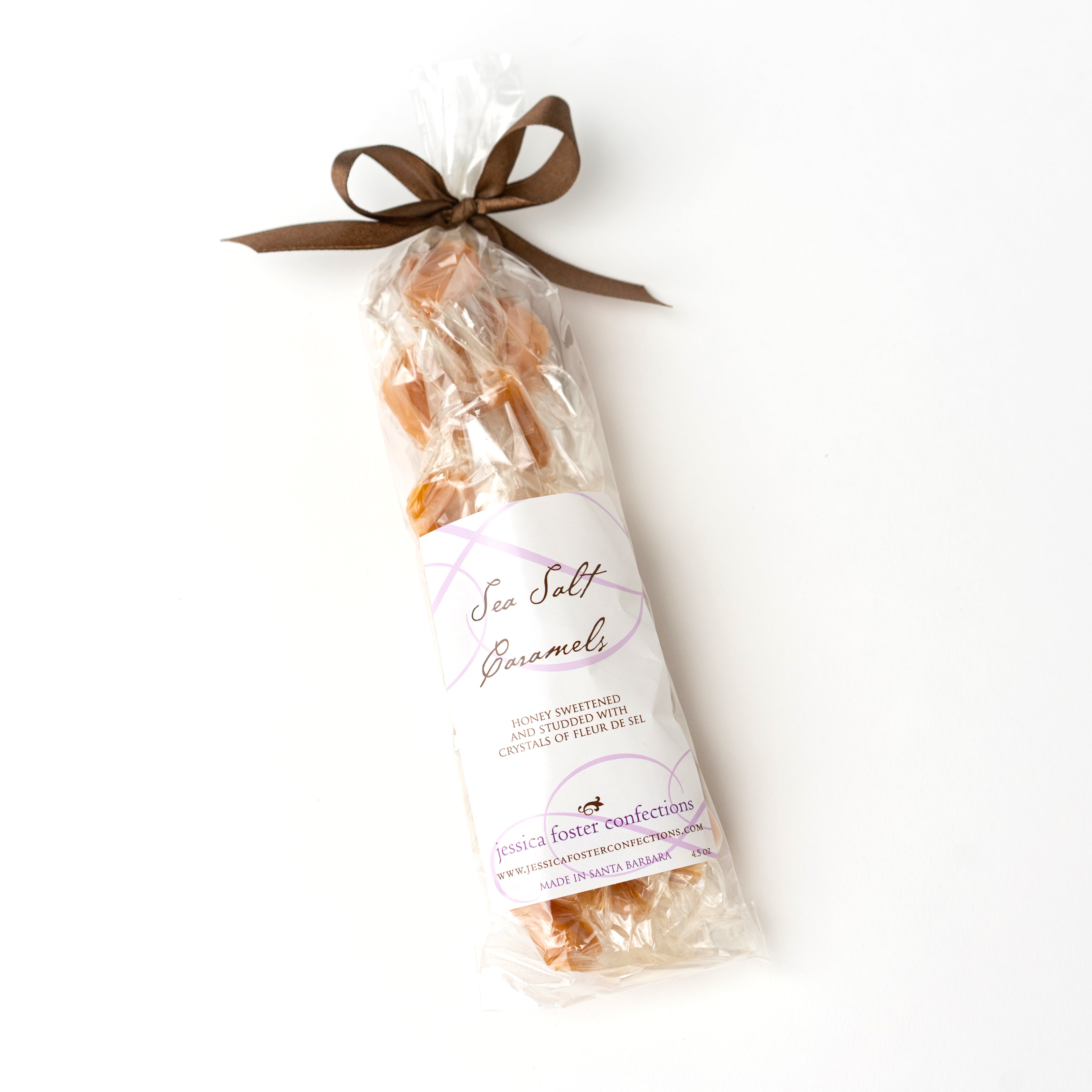 Clear plastic bag filled with small caramels, tied closed with a brown bow