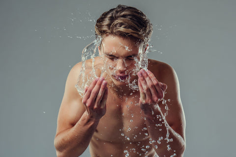 man washing face with hot water
