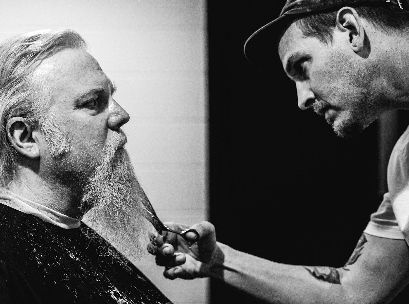 Barber trimmng mans beard