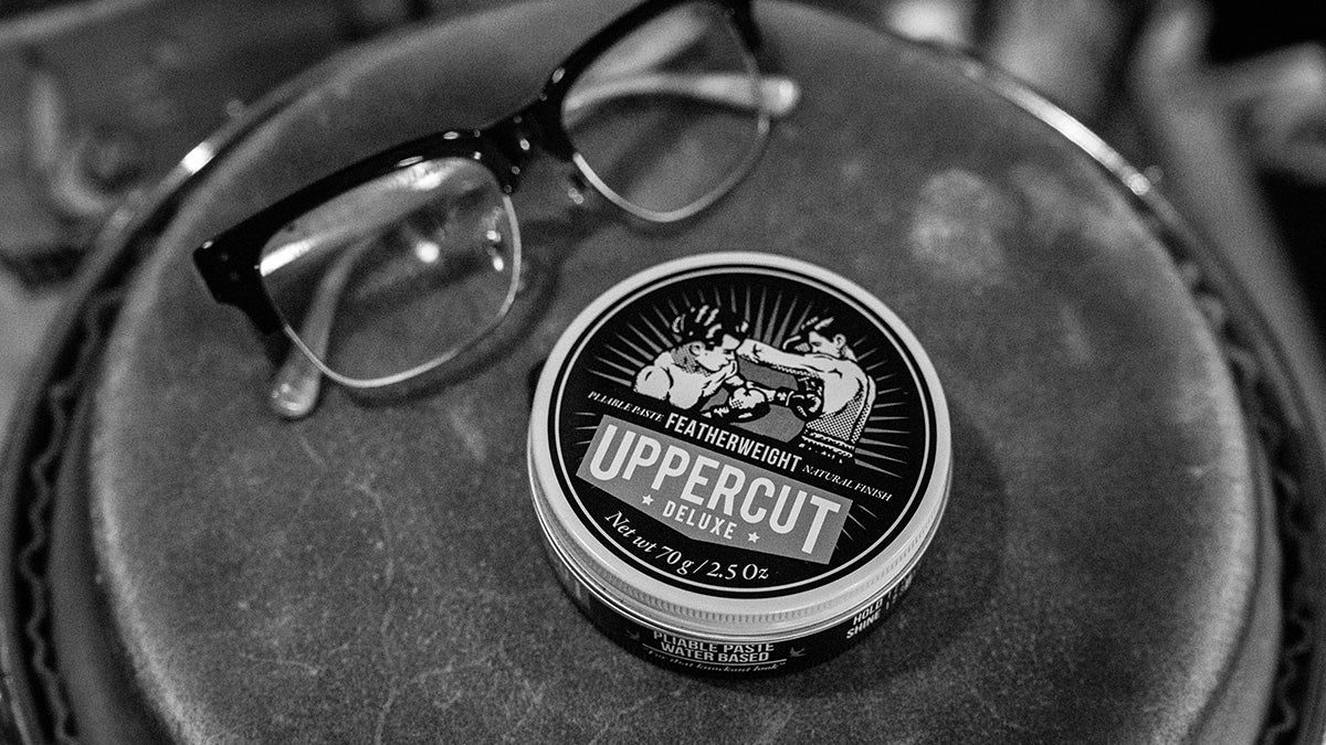 Tin of Uppercut Deluxe Featherweight and glasses