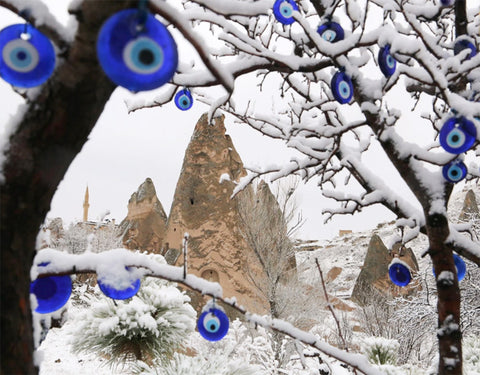 Evil eye discs were hung on a snowy tree amid the famous volcanic rock formations of Cappadocia, a region in Turkey