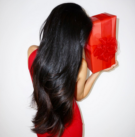Back of Leyla Milani in red dress holding a red present