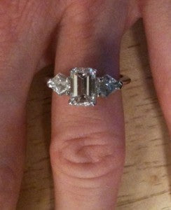 round diamond with emerald cut side stones