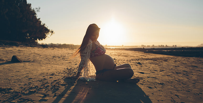 Pregnant at sunset in Point Cartwright beach in the Sunshine Coast of Australia